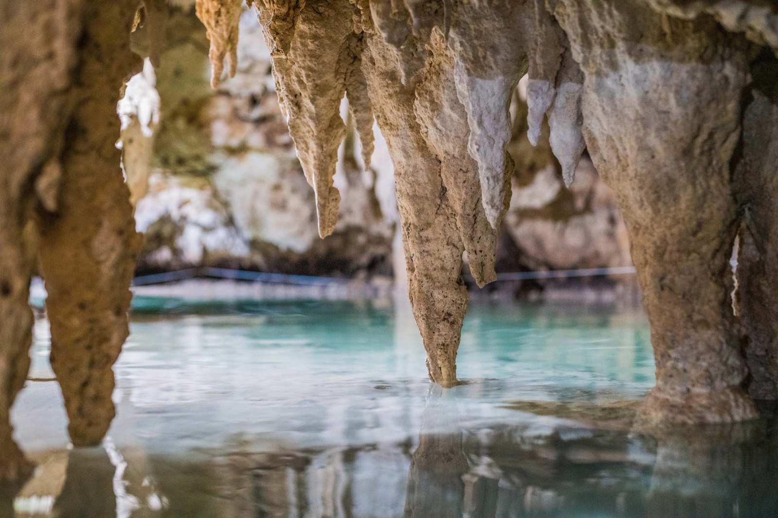 Estalactitas sobre el agua turquesa de un cenote de caverna