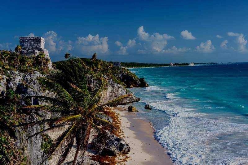 Acantilado de Tulum con palmeras y playa frente al mar
